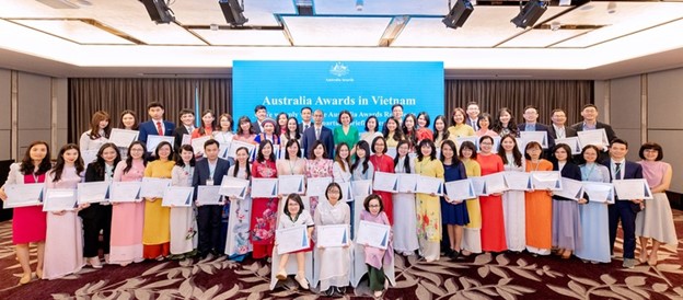 55 new Vietnamese scholars receiving Australia Awards Scholarship certificates.