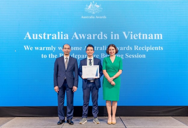 Lo Van Long receiving a scholarship certificate.